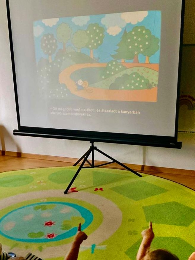 Kinder zeigen auf die Leinwand