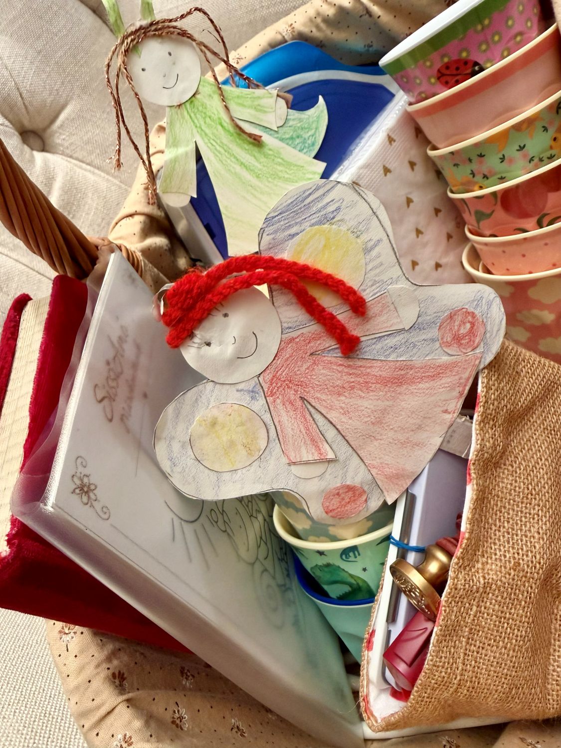 Ausgemalte Papierfiguren mit roten Wollhaaren im Korb